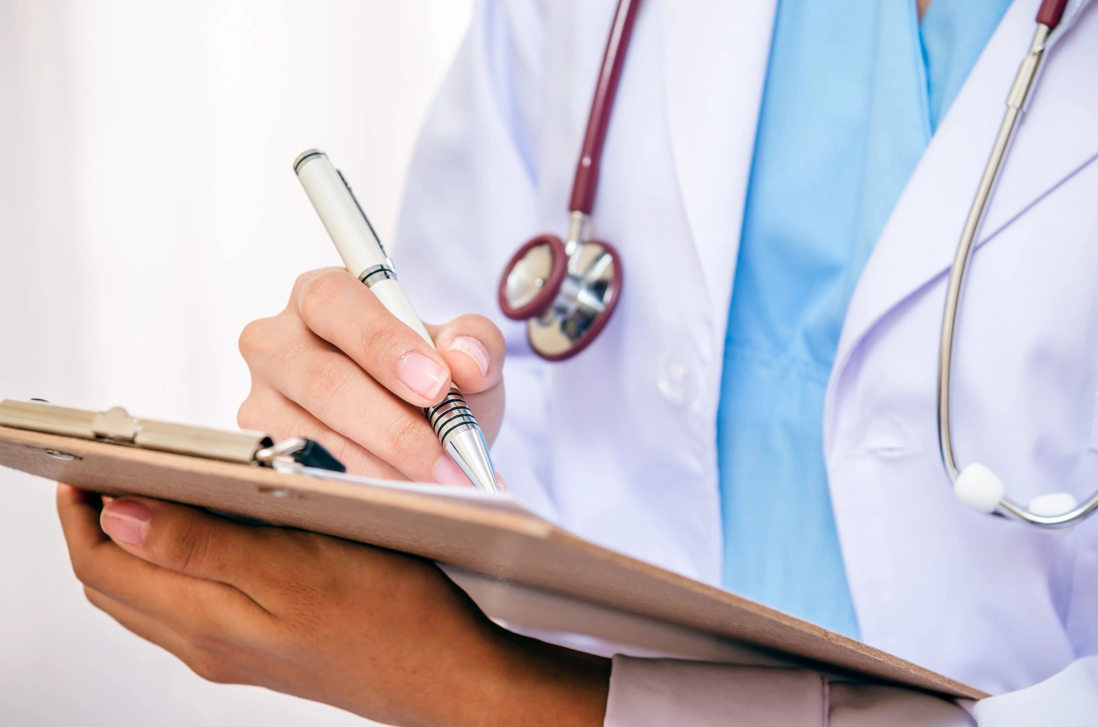 Doctor conducting a history taking examination from clipboard.