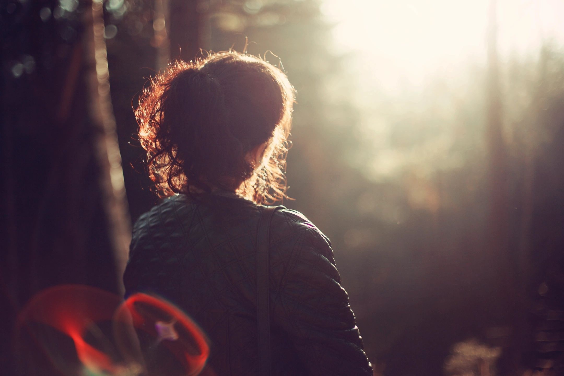 Understanding Mental Health - Person Female looking into the distance in thought. In woodland scene.