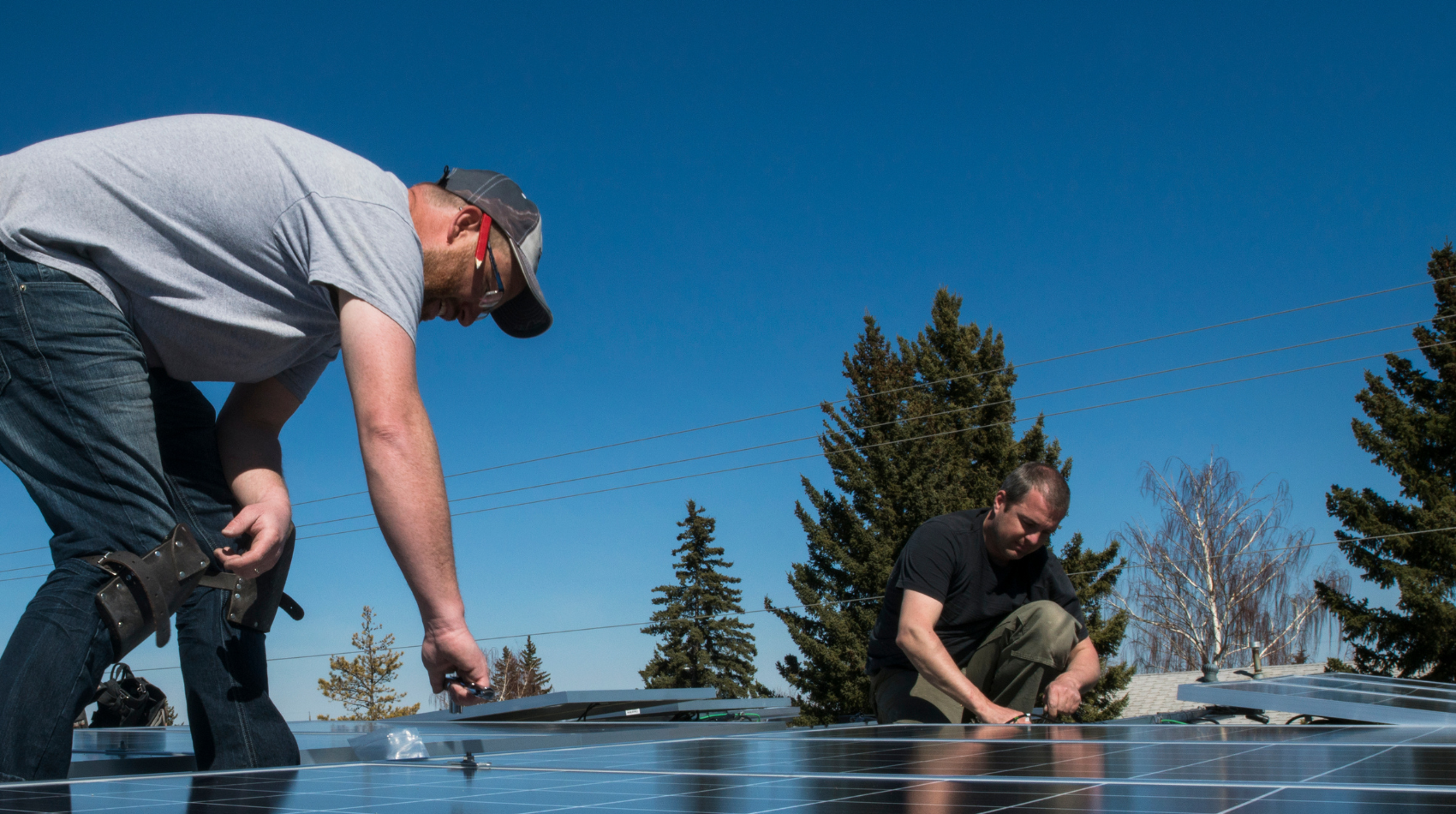 Employer - Solar PV installation team on roof with pine tree background